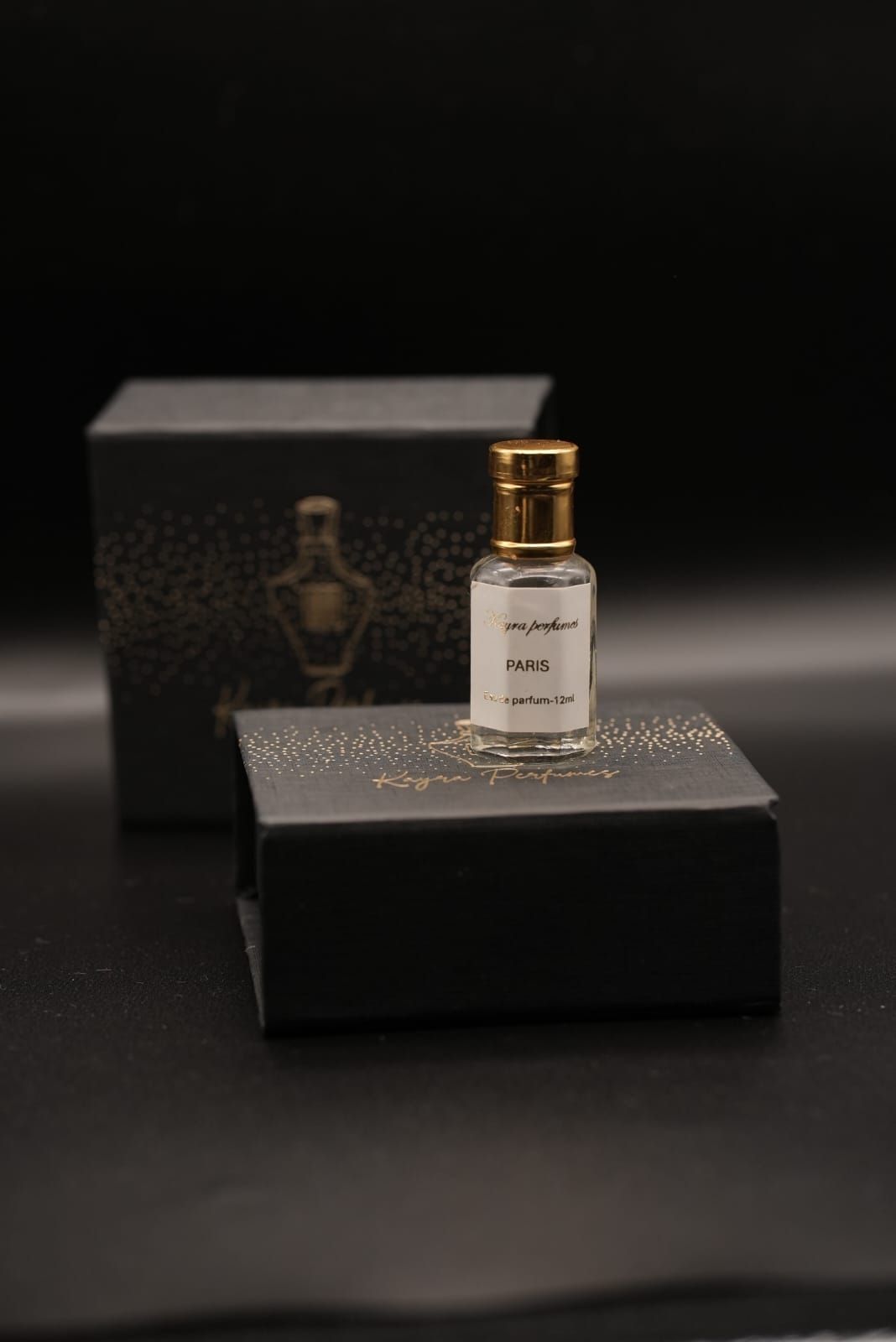 Kayra Perfumes Paris eau de parfum bottle beside its black gold-foiled box